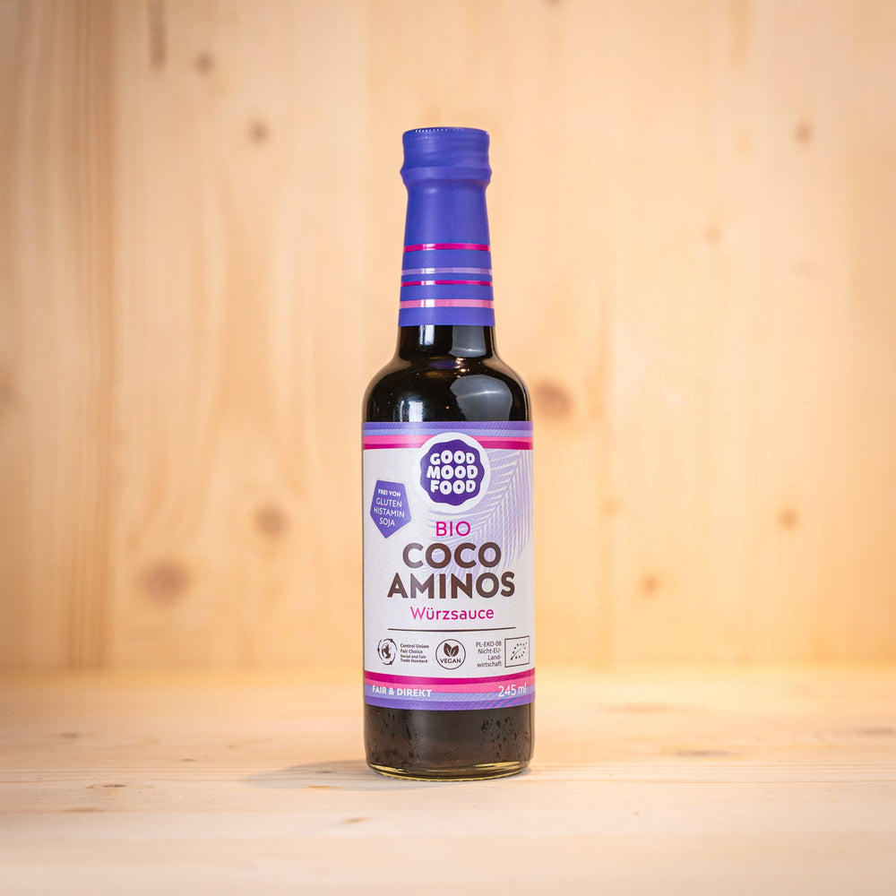 Coco Aminos Würzsauce BIO glutenfrei von GOOD MOOD FOOD in einer Glasflasche auf einem Holzuntergrund.
