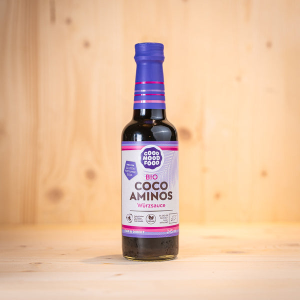 Coco Aminos Würzsauce BIO glutenfrei von GOOD MOOD FOOD in einer Glasflasche auf einem Holzuntergrund.