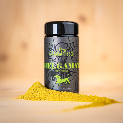 HELGAMAT Streuwürze BIO in einem Behälter neben gelber Streuwürze auf Holzuntergrund - Bio Streuwürze für Umami Geschmack.