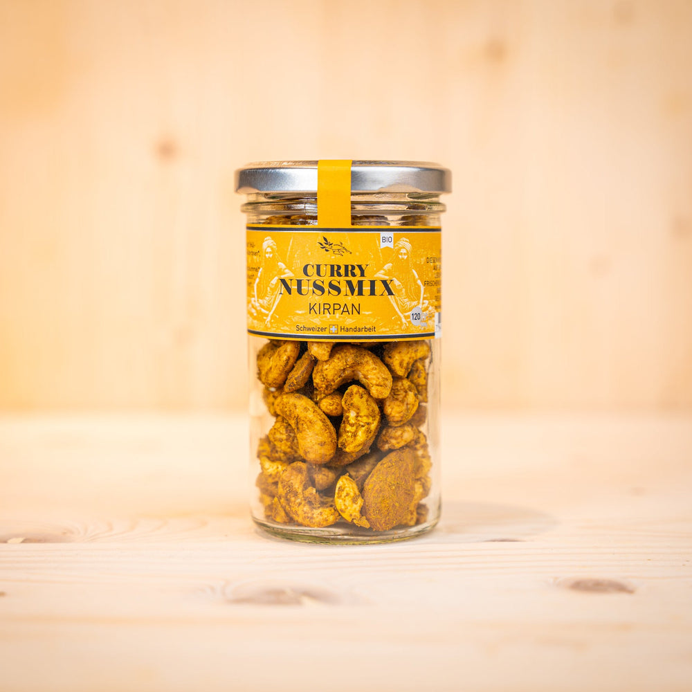 Curry-Nussmix – KIRPAN BIO in einem Glasbehälter, köstliche curry nüsse snacks mit frischem Curry-Geschmack.
