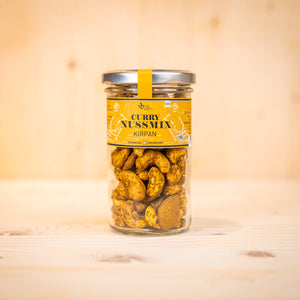 Curry-Nussmix – KIRPAN BIO in einem Glasbehälter, köstliche curry nüsse snacks mit frischem Curry-Geschmack.