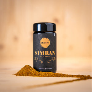 SIMRAN Ras el hanout BIO Gewürzverpackung mit Gewürzpulver auf Holzuntergrund.