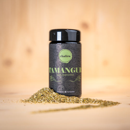 TAMANGUR BIO Kräutersalz „La Pesteda" 80% BIO in einer Glasdose mit Kräutermischung auf Holzuntergrund.