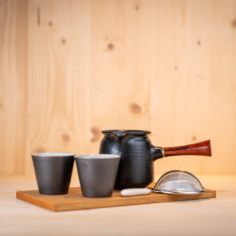 Tee-Set mit Teekanne, Teetassen, Tee-Sieb und Holzbrett